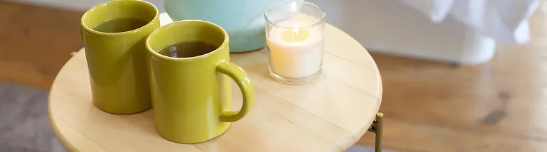 Two green caps of coffee and glass of milk.