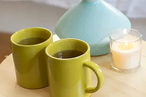 Two green caps of coffee and glass of milk.